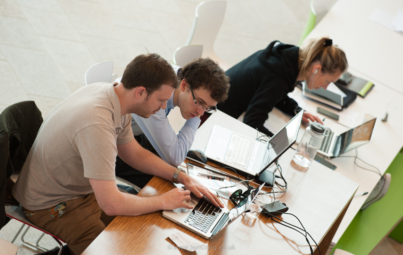 Computer Team Collaborating at Desk